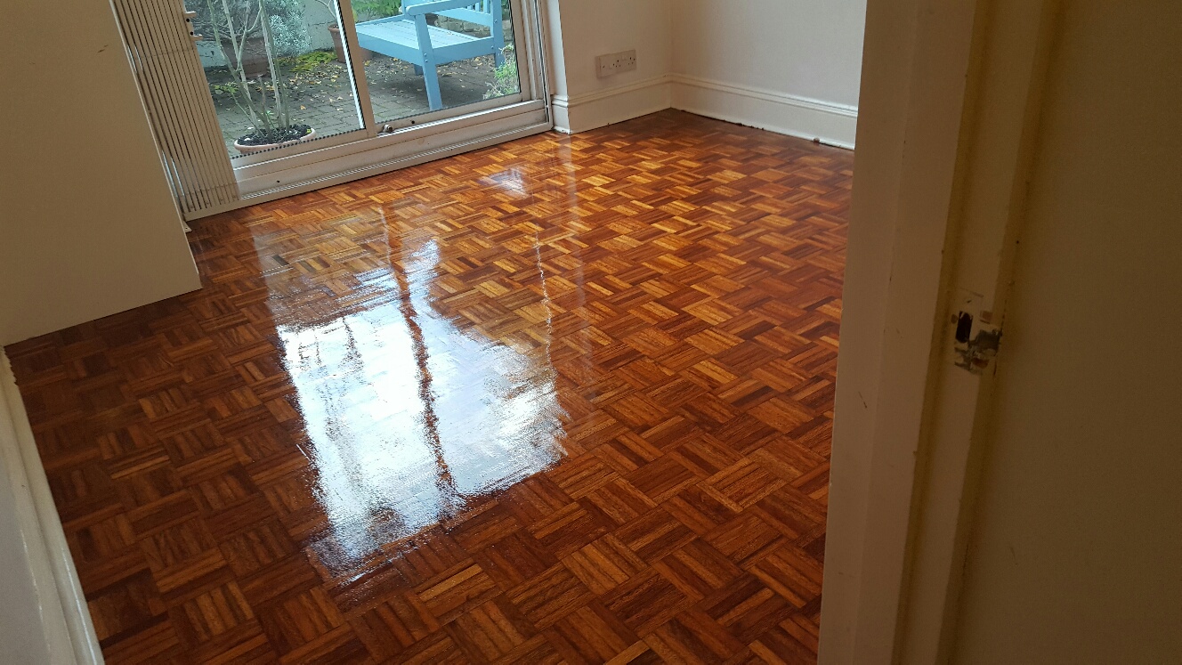 Wood Floor Sanding in Walthamstow – room showcasing a freshly lacquered oak parquet block floor, reflecting garden light through patio doors.