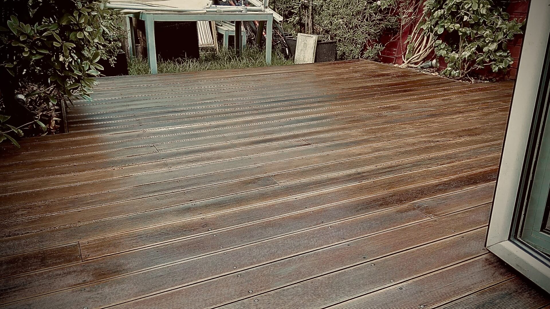 Freshly restored grooved softwood pine decking after Deck Sanding in Walthamstow, showing a smooth, dark-stained outdoor deck floor.