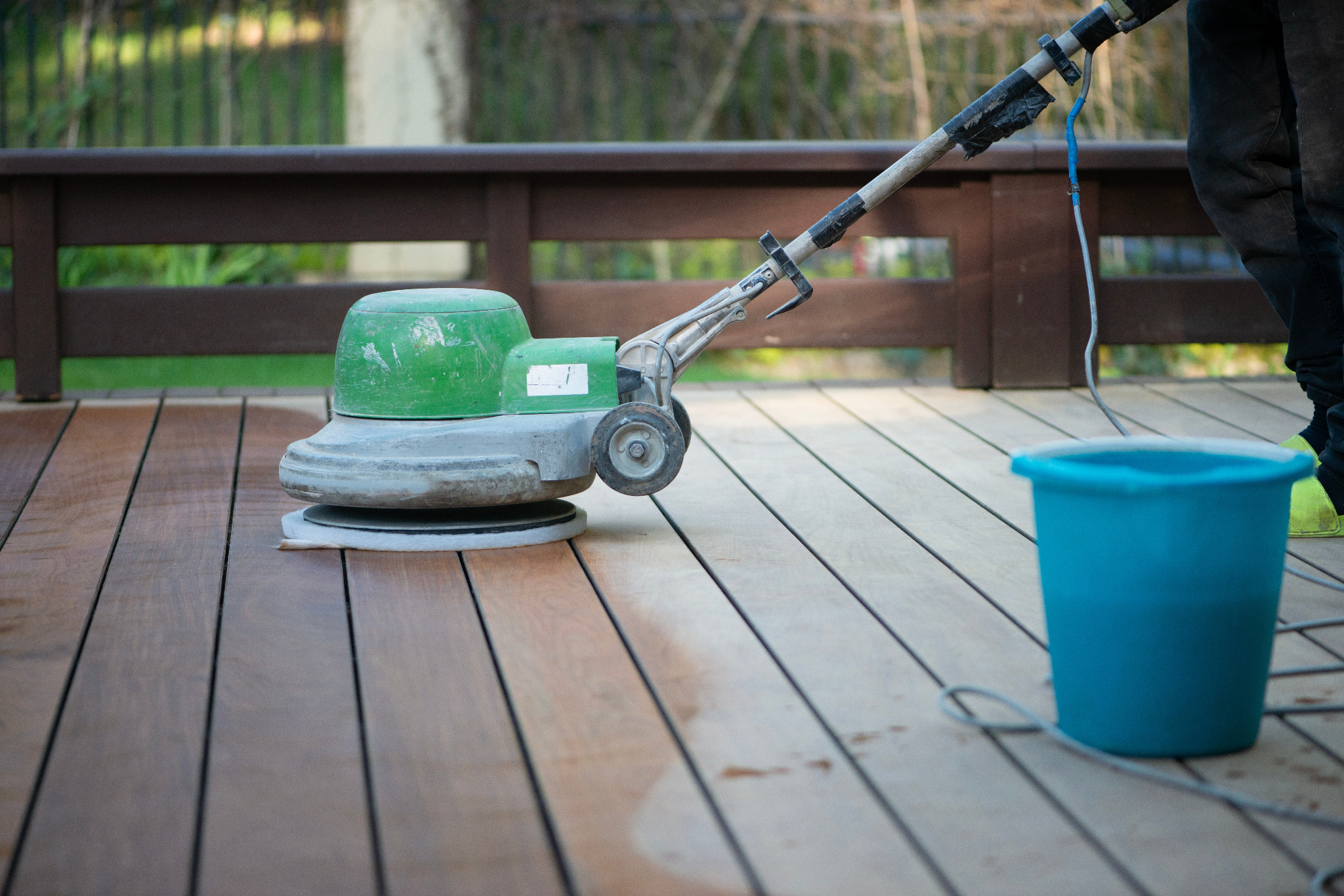 Rotary machine carrying out Deck Sanding in Walthamstow on hardwood timber decking, showing freshly sanded and darker restored deck boards.