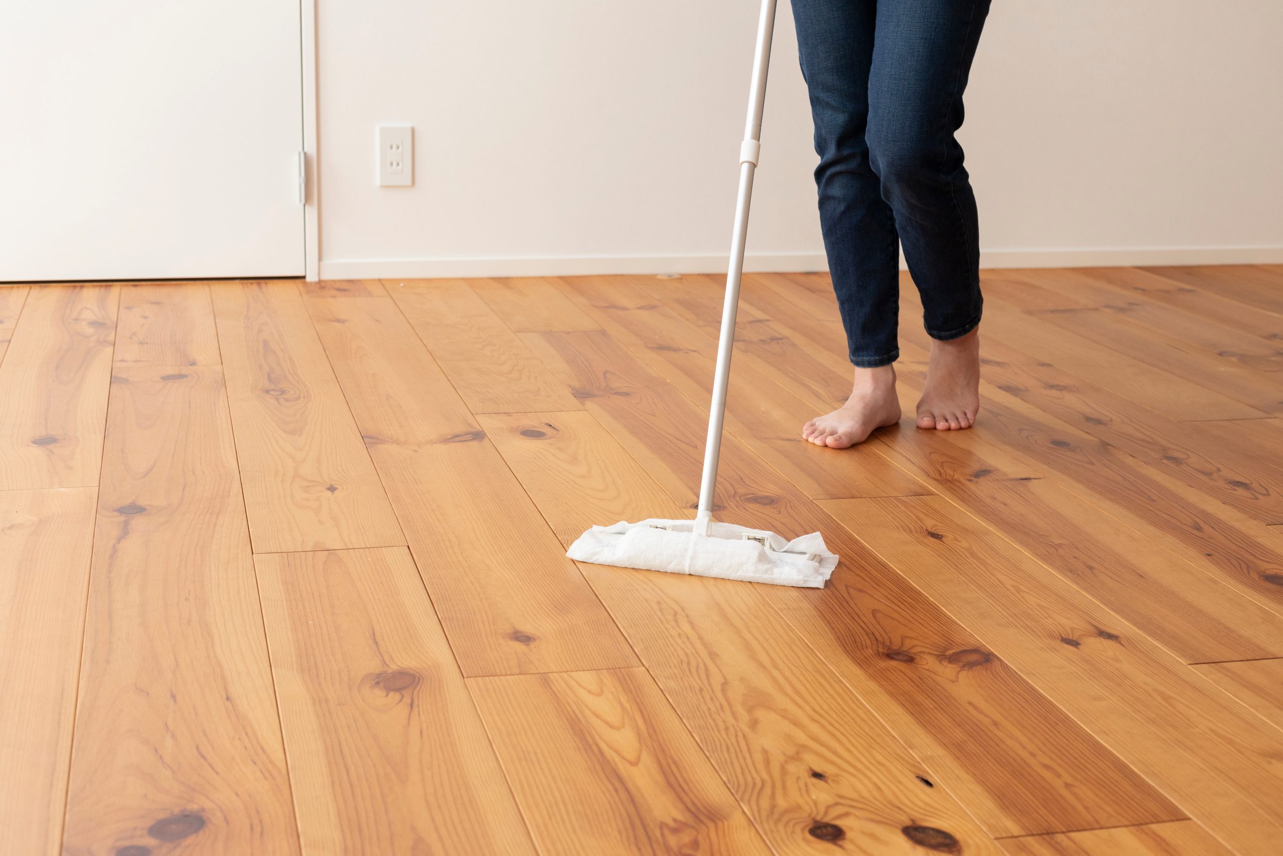 After Wood Floor Sanding in Walthamstow, a homeowner gently mops an engineered oak hardwood floor, keeping the newly restored boards clean and protected.