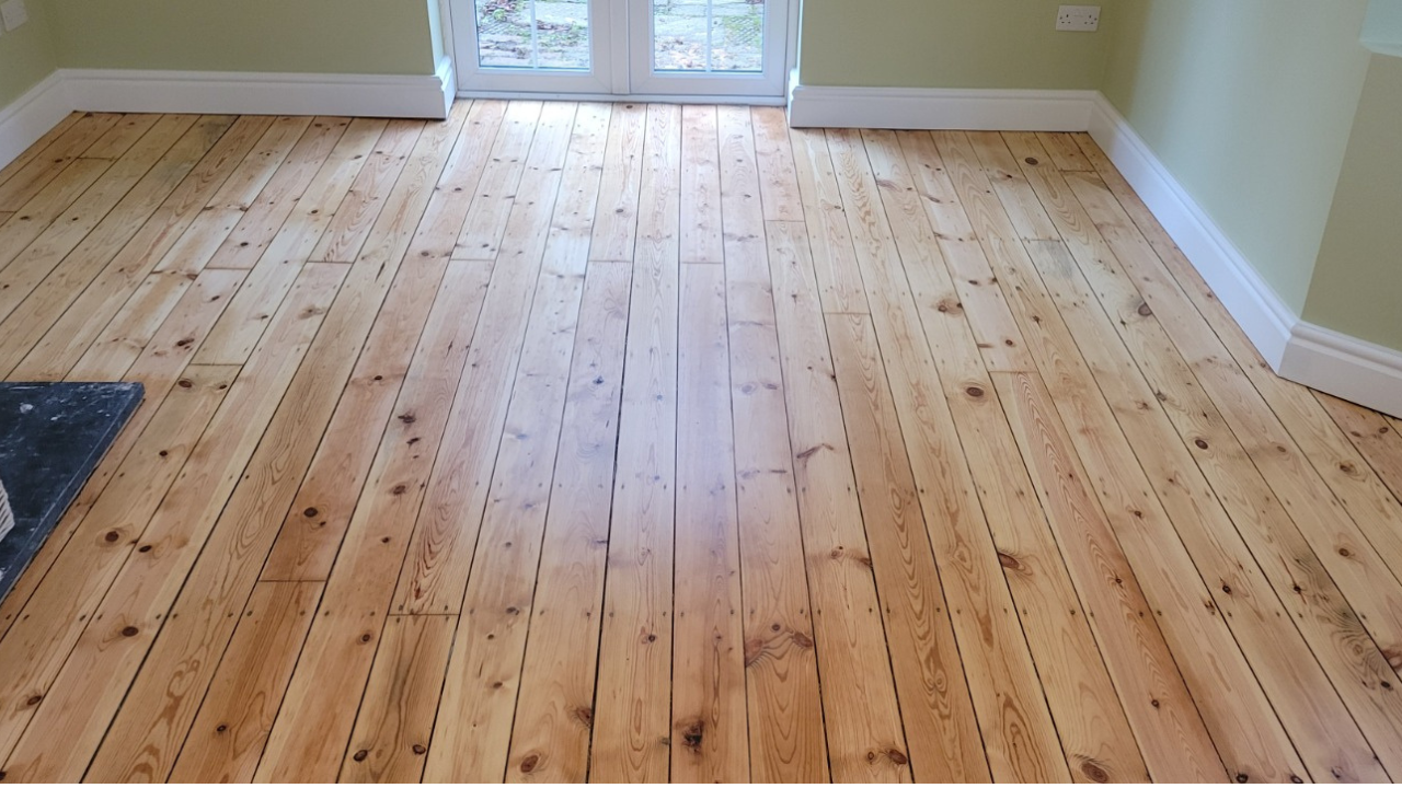 Wood Floor Sanding in Walthamstow on restored pine softwood floorboards, showing a bright, smooth finish in a light living room with patio doors.