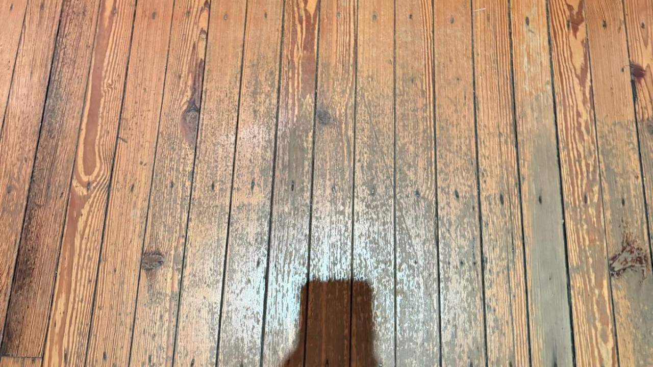 Worn pine floorboards in a Walthamstow home showing heavy wear and staining before Wood Floor Sanding and restoration.