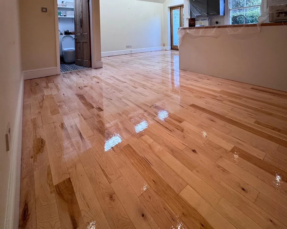 Hardwood Floor Refinishing in Walthamstow showing a light oak strip hardwood living room floor with a smooth glossy restored finish